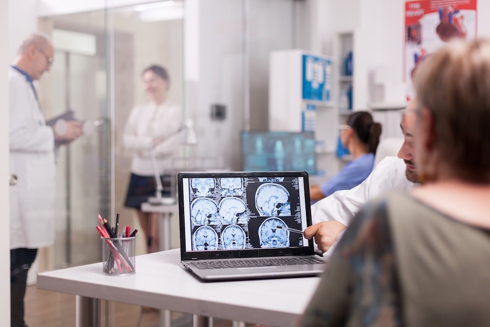 Healthcare professionals discussing MRI scans in a medical office setting.